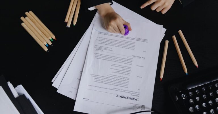 Mãos assinando carta de anuência sobre mesa com documentos acadêmicos