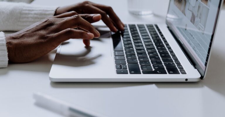 Mãos digitando e-mail profissional em laptop, preparando mensagem de contato a potencial orientador