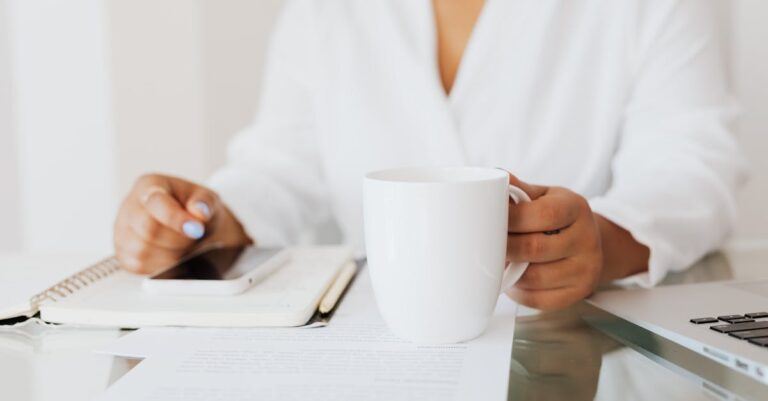Pessoa consultando instruções de submissão em tablet sobre mesa, mãos visíveis