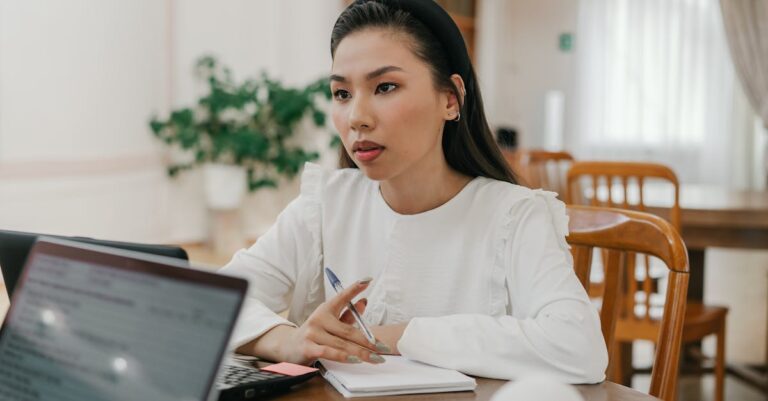 Pessoa ensaiando apresentação com laptop, cronômetro e notas sobre a mesa, vista parcial por cima.