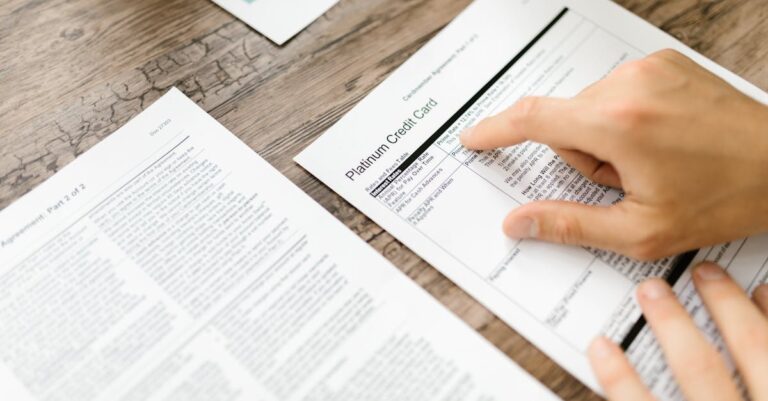 Pilha de documentos de candidatura, proposta impressa e checklist em prancheta, vista superior.