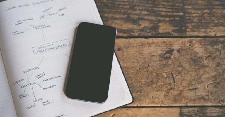 Pesquisador escrevendo plano de ação em caderno aberto ao lado de laptop em ambiente minimalista e iluminado