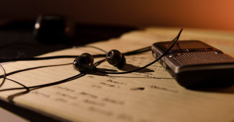 Pesquisador usando fones de ouvido escutando áudio enquanto anota em caderno em setup minimalista