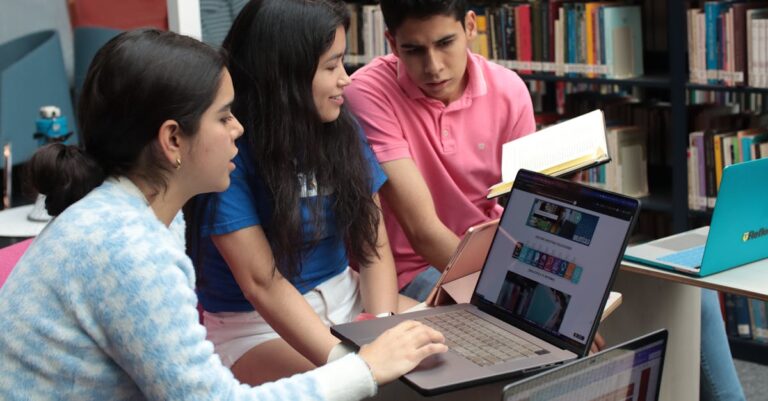 Pesquisador sorridente analisando documento aprovado em laptop em ambiente de trabalho sereno