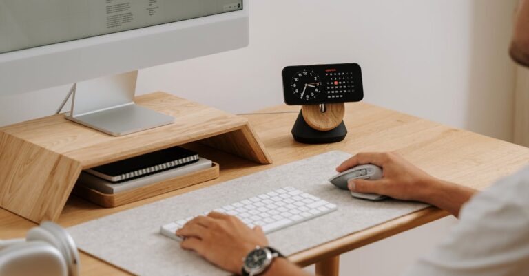 Mesa de trabalho minimalista com laptop, caderno e elementos organizados sob luz natural