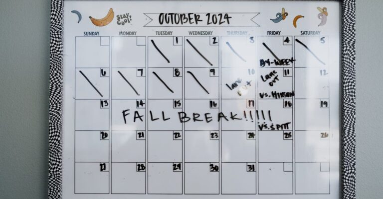 Mão marcando calendário de 7 dias em planner acadêmico sobre mesa com caneta e notes