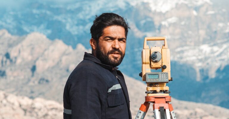 Pesquisador coletando e revisando respostas de questionário piloto em planilha digital minimalista