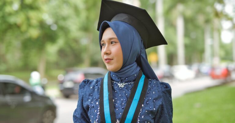 Pilha de jornais acadêmicos e pesquisador celebrando publicação em mesa com luz natural