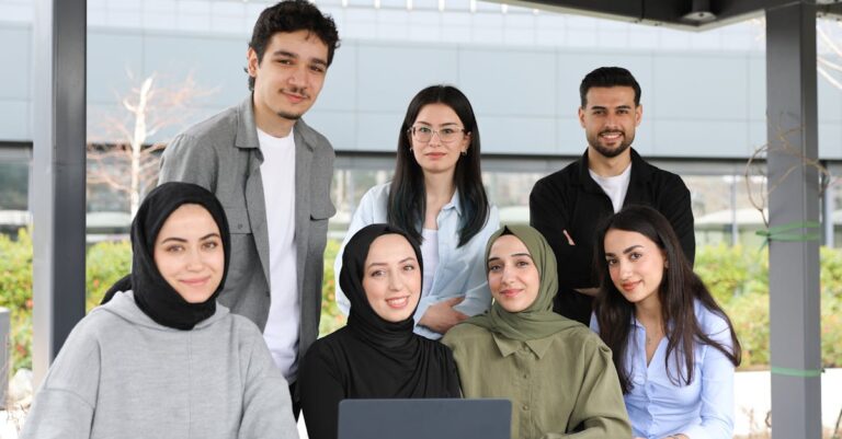 Equipe acadêmica discutindo em reunião com documentos e laptop em sala iluminada naturalmente