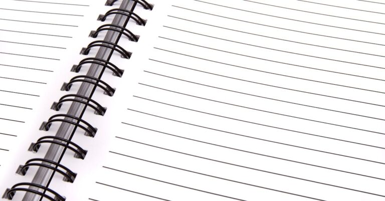 Pesquisador escrevendo plano de gestão de dados em notebook com foco sério