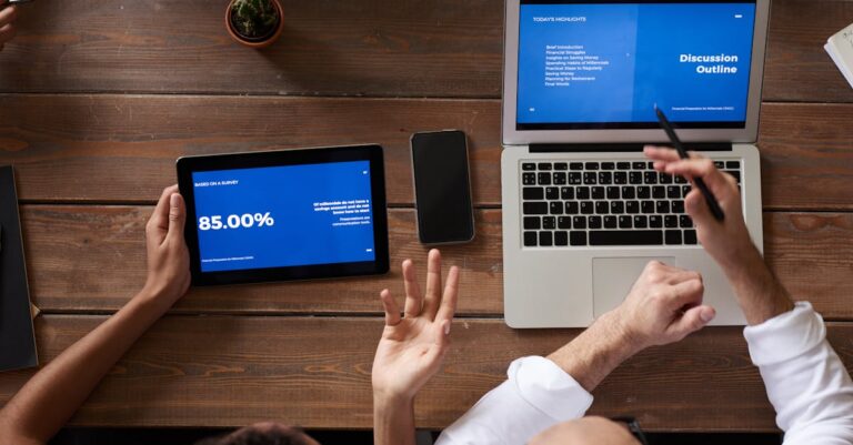 Grupo de pesquisadores discutindo teoria em mesa com cadernos e laptop em ambiente luminoso