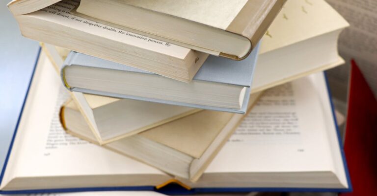 Pesquisador caminhando confiante com pilha organizada de livros rumo ao sucesso acadêmico