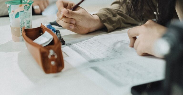 Estudante de pós-graduação escrevendo passos de plano em notebook com ambiente profissional limpo