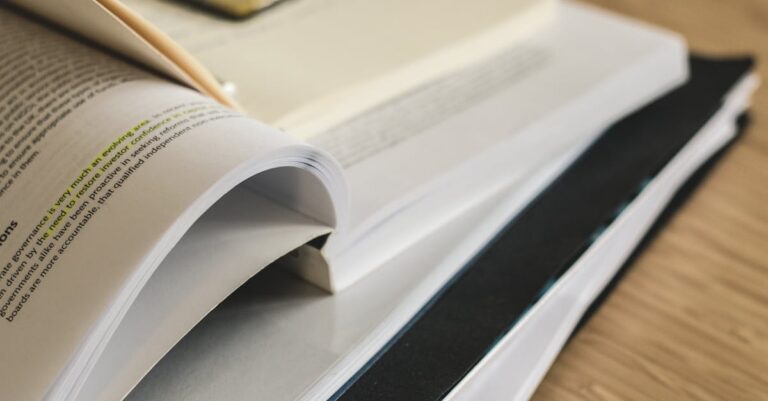 Mulher destacando texto em livro acadêmico sobre mesa clara com foco na página