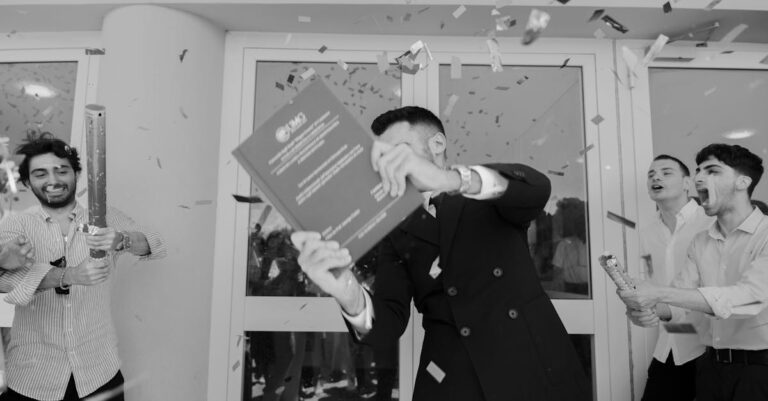 Doutorando celebrando aprovação de tese com documento e laptop em ambiente acadêmico sereno.