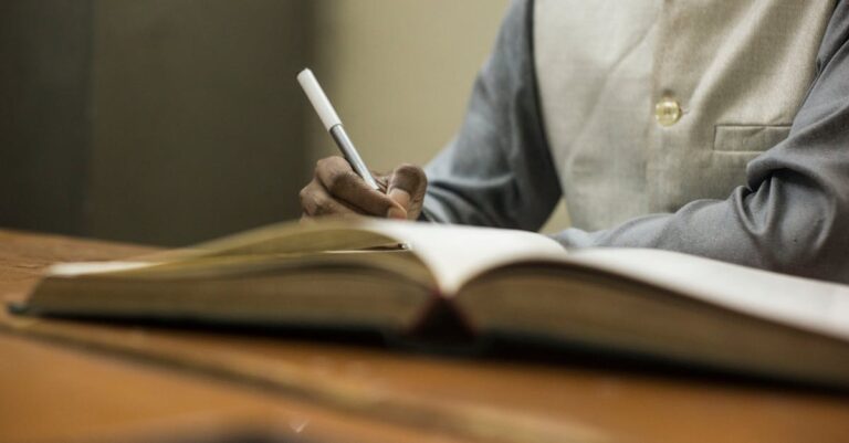 Pesquisador segurando revista acadêmica publicada com expressão de realização em fundo claro