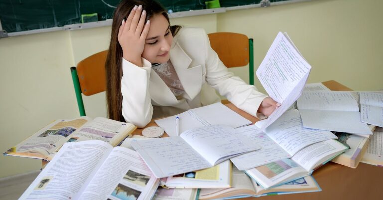 Pesquisador sério lendo comentários de revisores em tela de computador, expressão pensativa, mesa organizada