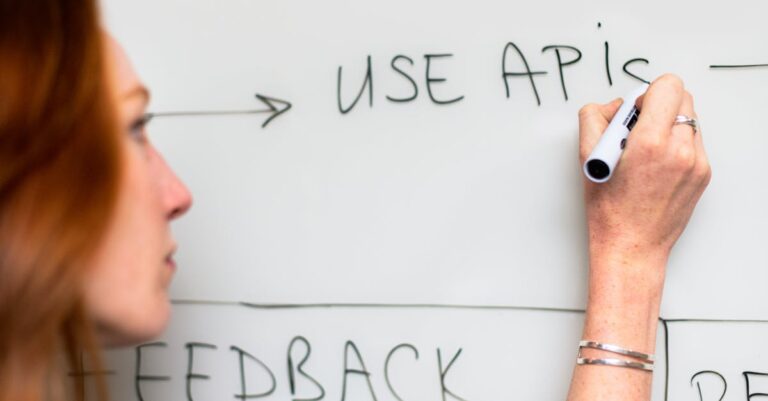 Pesquisador desenhando fluxograma de metodologia em laptop sobre mesa clara com iluminação natural.