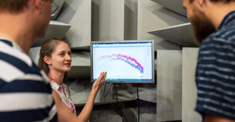 Pesquisador gravando simulação de apresentação com laptop em ambiente minimalista
