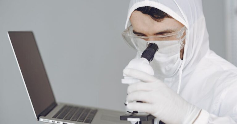 Pesquisadora focada analisando publicações em laptop com notas ao lado