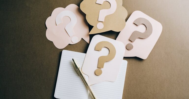 Mulher pesquisadora escrevendo pergunta de pesquisa em caderno com laptop ao lado