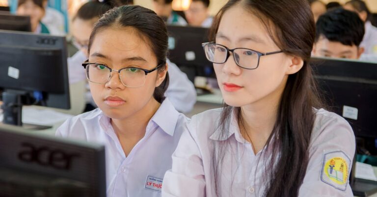 Pesquisadora organizando post-its com códigos em tabela para formar temas em mesa clara