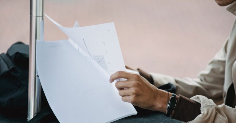 Estudante pesquisador editando tabela de dados em laptop sobre mesa organizada