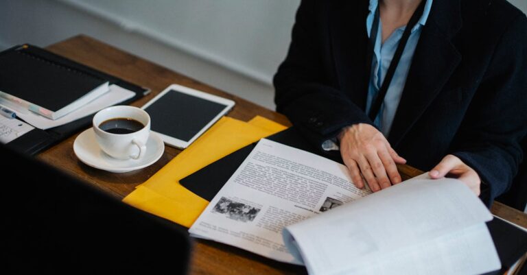 Analista revisando documentos acadêmicos e editais em setup minimalista de escritório