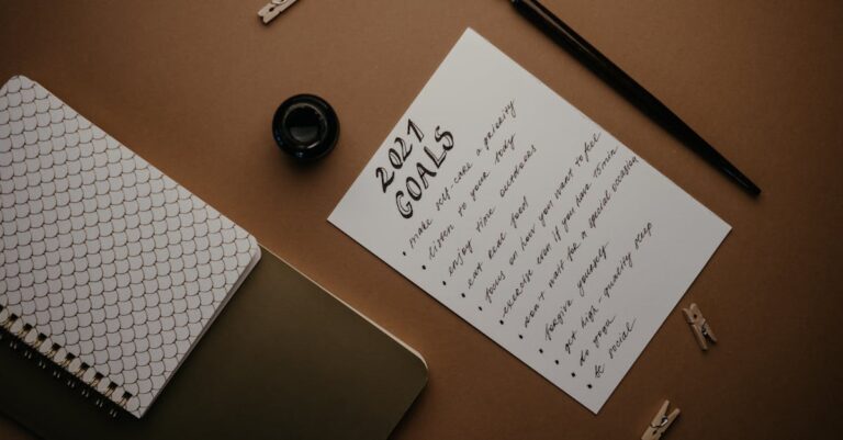 Pesquisador escrevendo objetivo micro em post-it amarelo ao lado do notebook