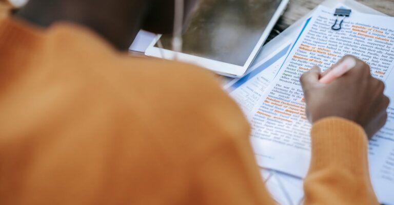 Estudante de pesquisa revisando anotações metodológicas em caderno com expressão concentrada e mesa organizada