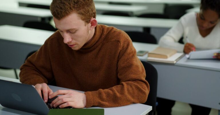 Mulher focada digitando texto acadêmico em laptop com fundo limpo e iluminação natural