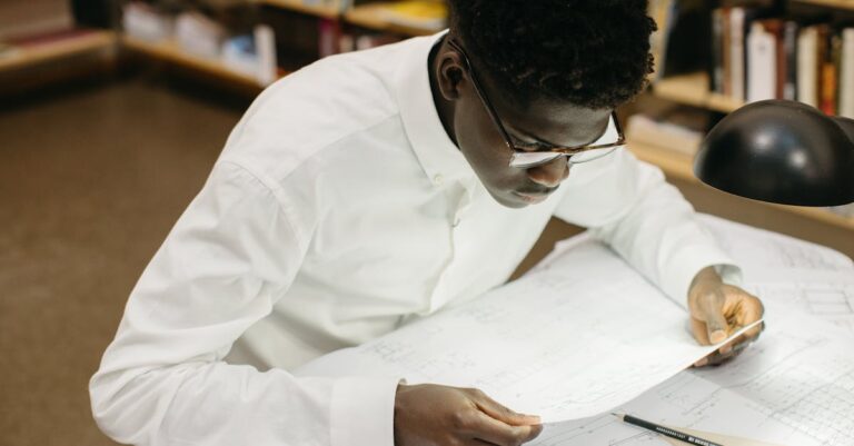 Estudante focado escrevendo notas de planejamento em notebook sobre pesquisa acadêmica