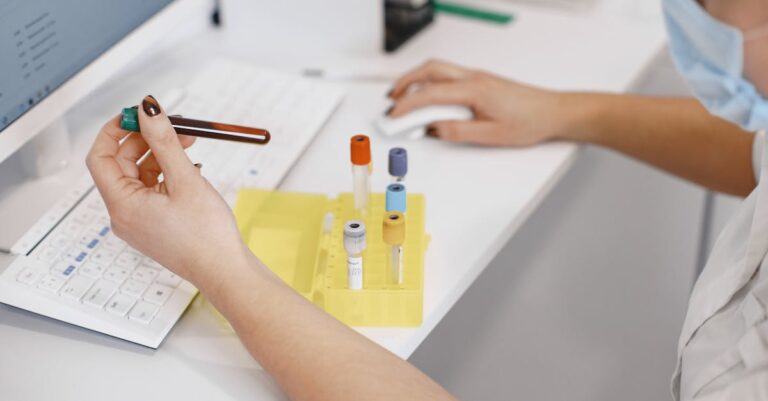 Pesquisador verificando pré-requisitos de amostra e dados em tela de computador com seriedade