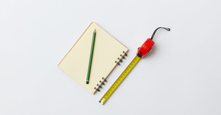 Mão escrevendo notas traduzindo conceitos abstratos para medidas empíricas em caderno aberto