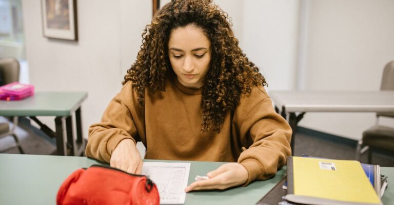 Estudante de doutorado preparando anotações para defesa de tese em mesa organizada