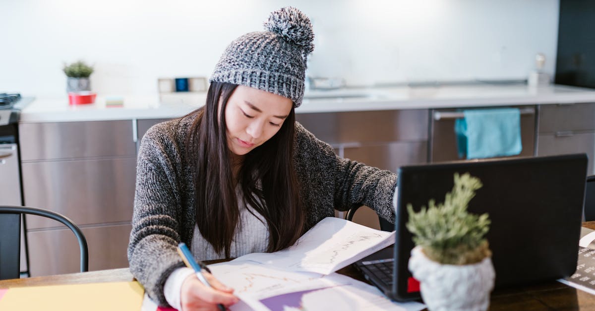 Pesquisador em escritório claro analisando gráficos de modelos estatísticos em laptop com balança simbólica