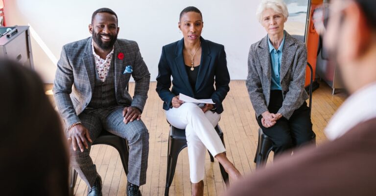 Pesquisador ouvindo atentamente durante apresentação acadêmica com expressão concentrada.