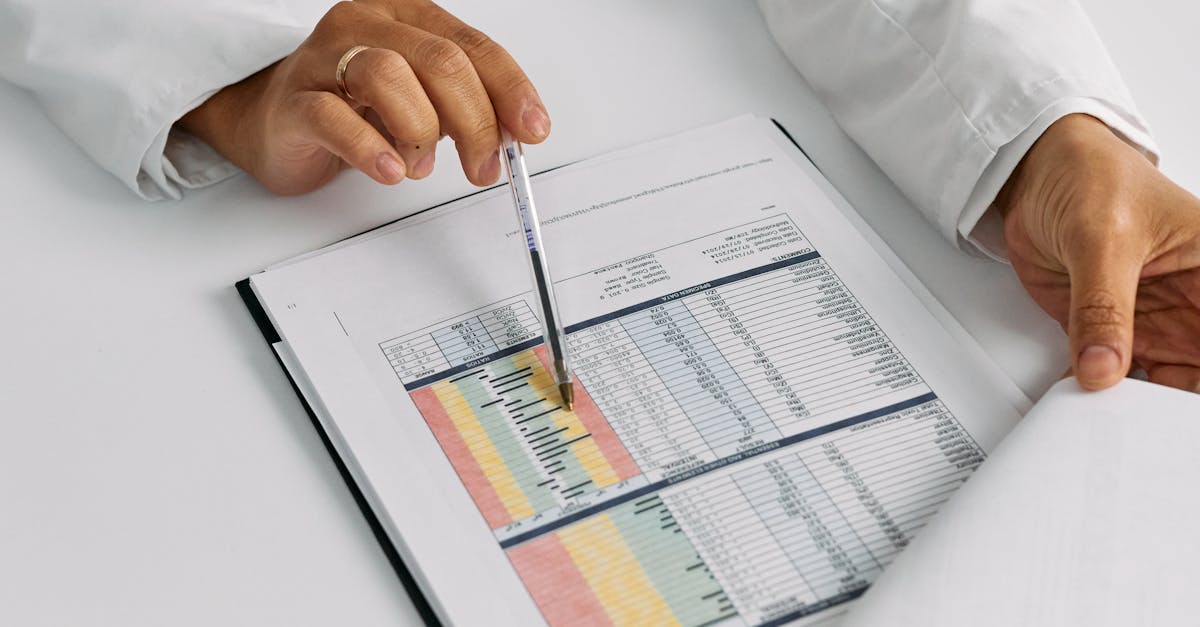 Pesquisador focado analisando gráficos e tabelas de dados em tela de computador com iluminação natural