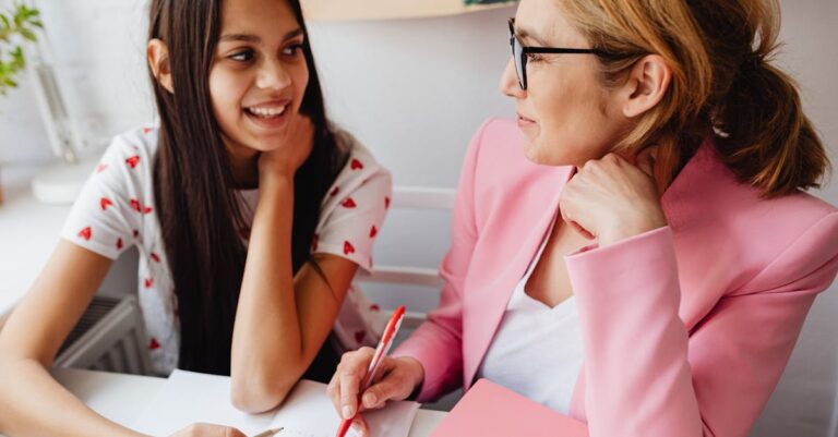 Orientador e estudante discutindo projeto de pesquisa com documentos sobre mesa iluminada naturalmente