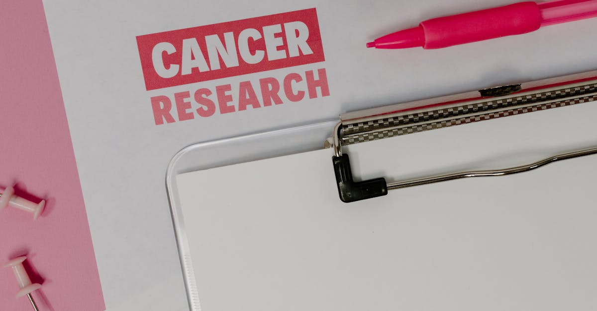 Pesquisador focado escrevendo em notebook com laptop ao lado em ambiente claro e minimalista