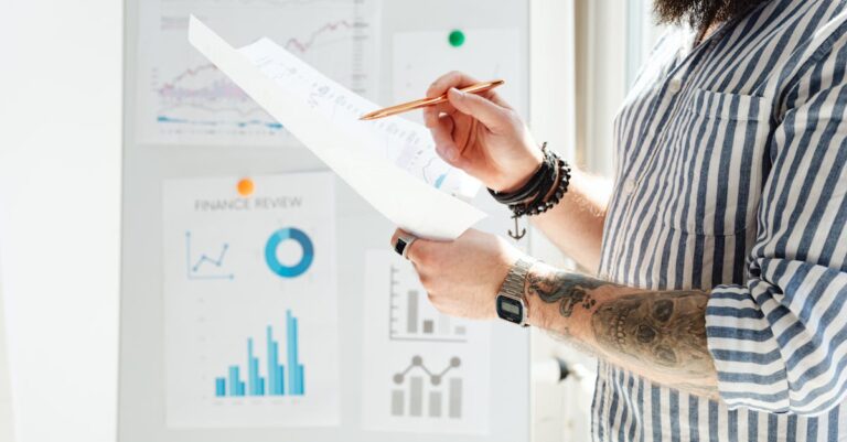 Pesquisador acadêmico revisando relatórios estatísticos em mesa organizada com iluminação natural.