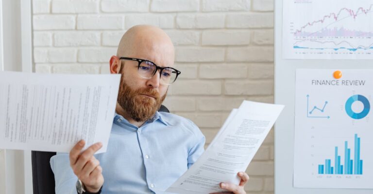 Pesquisador acadêmico revisando relatório detalhado em mesa com iluminação natural e fundo limpo