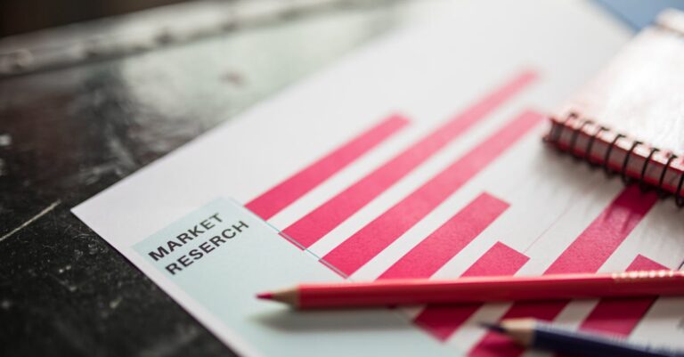 Pesquisador focado escrevendo notas sobre planejamento de elementos visuais em caderno aberto