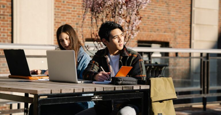 Estudante pesquisador confiante trabalhando em laptop com expressão de realização acadêmica