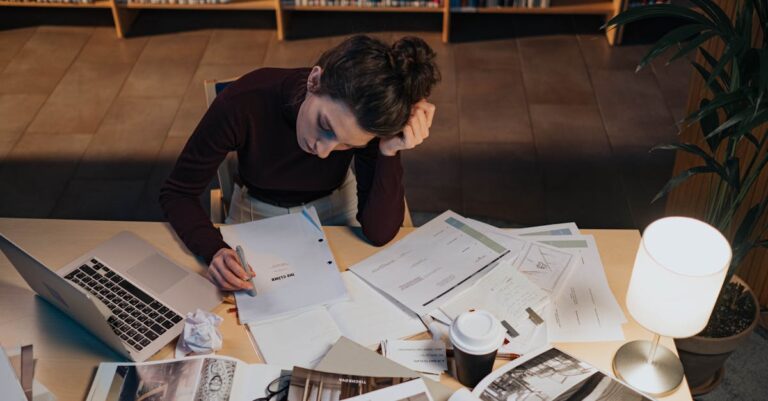 Pesquisador sério lendo anotações em caderno sobre mesa clara com fundo limpo