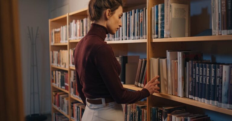 Mulher pesquisadora buscando artigos em laptop com bases de dados acadêmicas, fundo clean