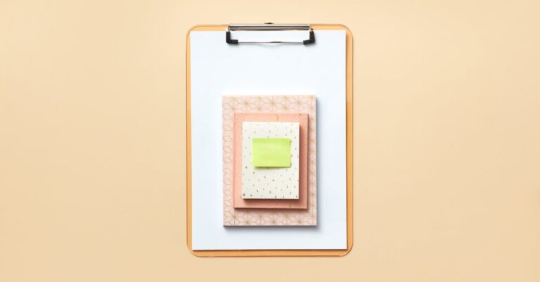 Estudante universitária marcando itens em checklist escrito em bloco de notas com caneta na mesa organizada