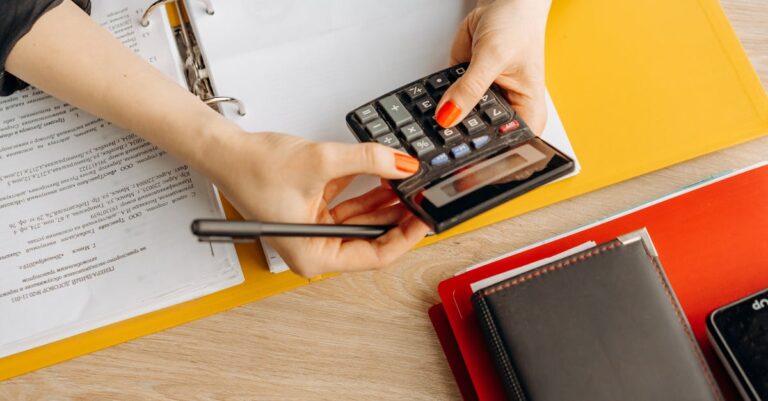 Mesa organizada com pastas de arquivos digitais e computador exibindo estrutura de projeto
