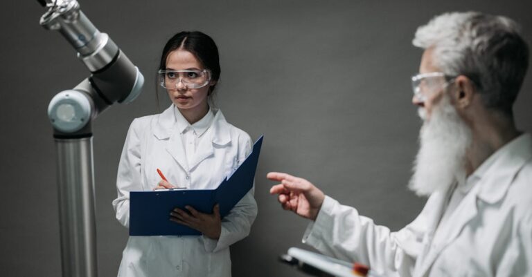 Dois pesquisadores colaborando na revisão de código em tela de laptop