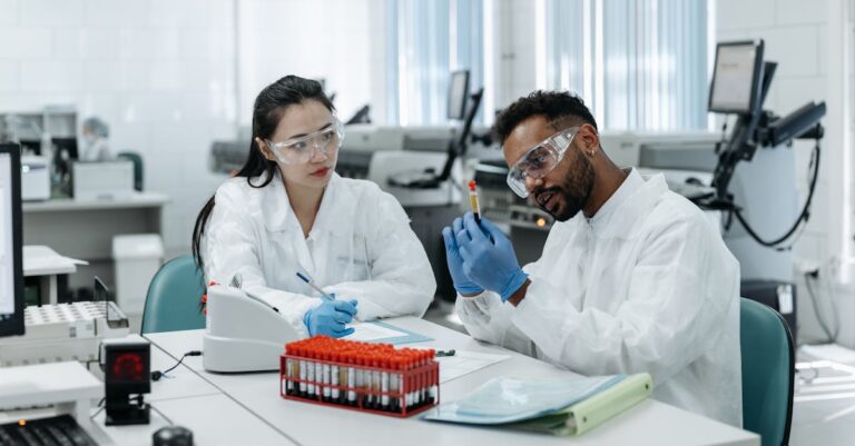 Pesquisador revisando tabela de análise de sensibilidade com gráficos de poder estatístico